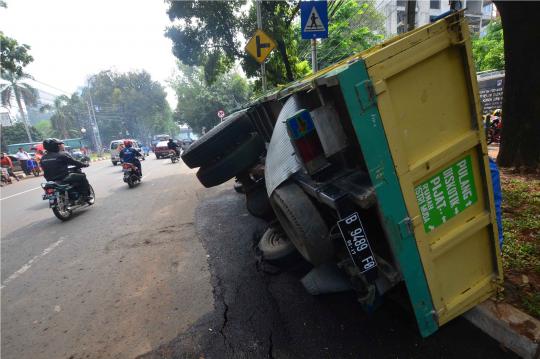 Akibat jalan amblas, truk semen terguling