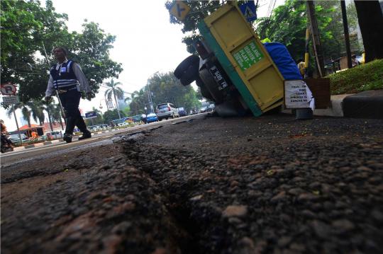 Akibat jalan amblas, truk semen terguling