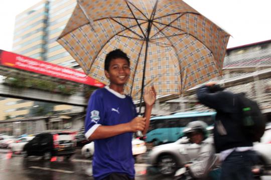 Jakarta diguyur hujan, jasa ojek payung laris manis