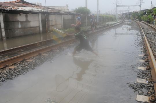 Rel kereta tergenang air, warga Kampung Bandan asyik cari ikan
