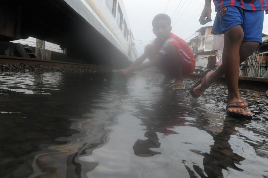 Rel kereta tergenang air, warga Kampung Bandan asyik cari ikan