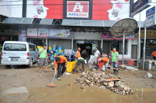 Bersih-bersih lumpur sisa banjir di Kampung Melayu