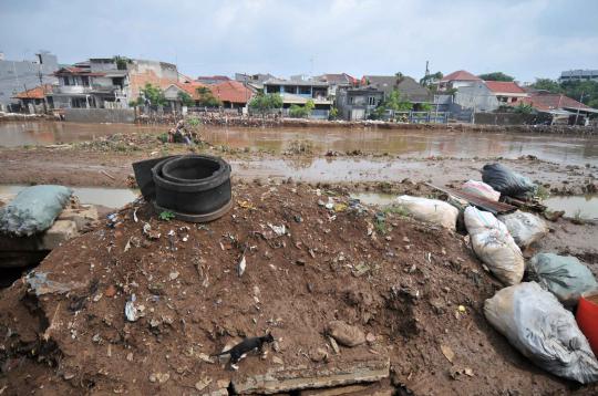Bersih-bersih lumpur sisa banjir di Kampung Melayu