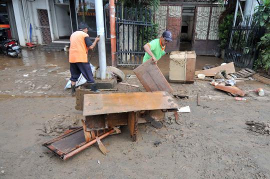 Bersih-bersih lumpur sisa banjir di Kampung Melayu