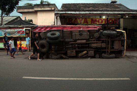 Penutup drainase rapuh, truk muatan kayu terguling di Pamulang