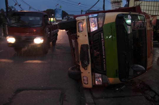 Penutup drainase rapuh, truk muatan kayu terguling di Pamulang