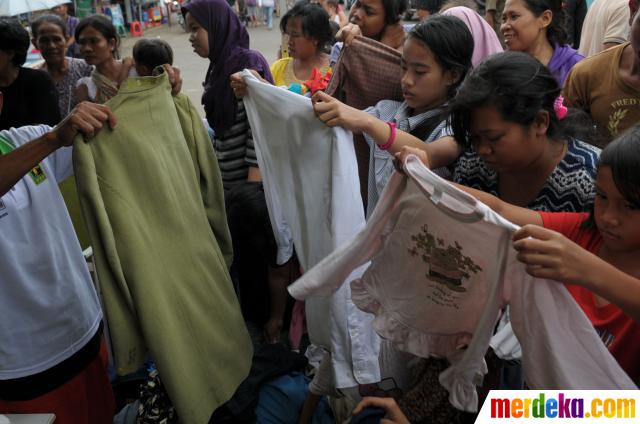 Foto : Warga korban banjir berebut pakaian di posko Parpol 