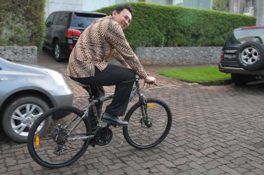 Ahok berbaju batik naik sepeda, pindah naik bus kota ke kantor