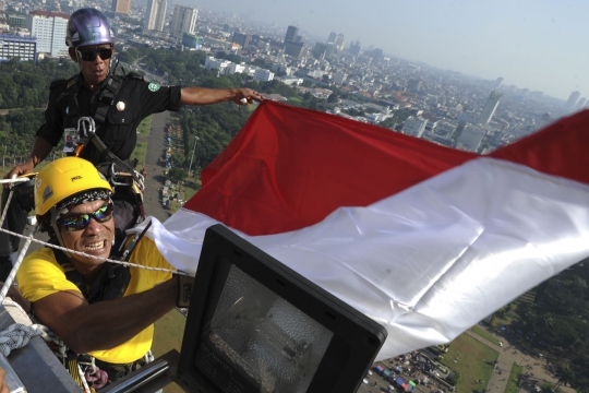 Aksi pria berkaki satu panjat Tugu Monas