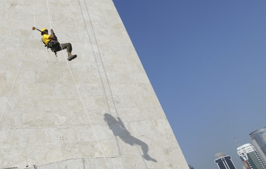 Aksi pria berkaki satu panjat Tugu Monas