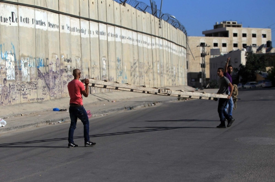 Hindari penjagaan Israel, warga Palestina panjat tembok pembatas
