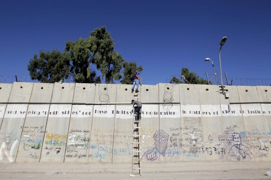 Hindari penjagaan Israel, warga Palestina panjat tembok pembatas