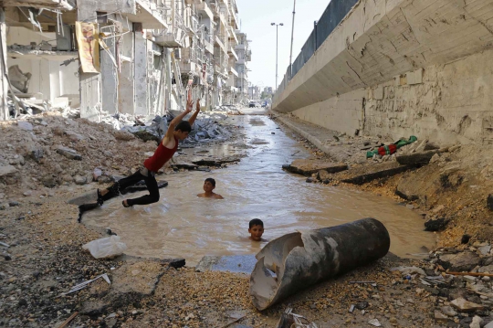 Keceriaan bocah Suriah main air di kubangan bekas serangan bom