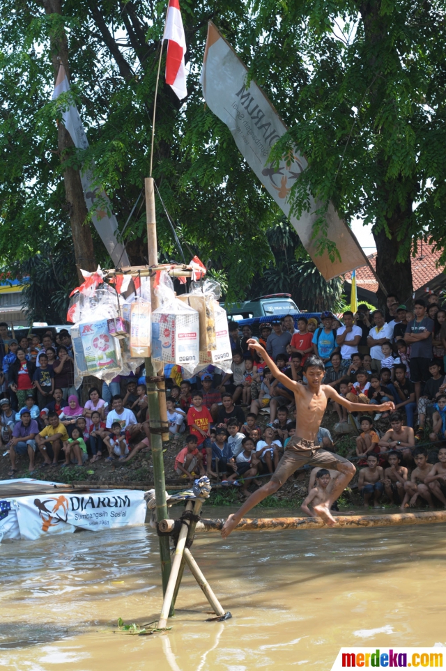 Foto : Serunya lomba berjalan di batang pinang yang licin 