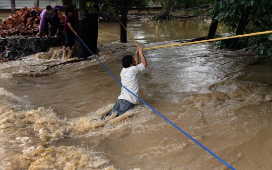 Aksi nekat warga India seberangi derasnya arus banjir