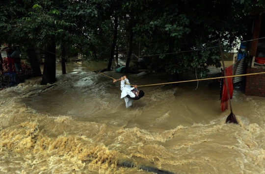 Aksi nekat warga India seberangi derasnya arus banjir