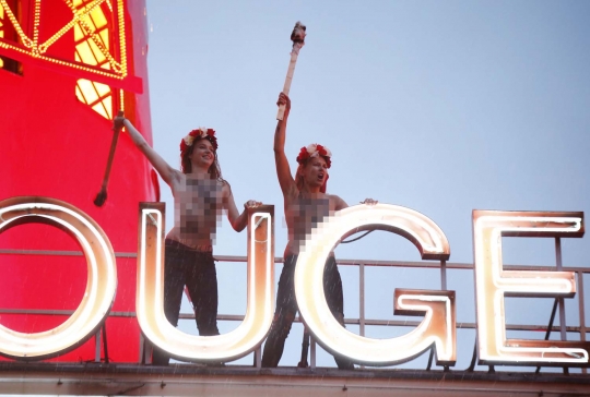 Wanita Femen nekat setengah bugil di atap gedung demo prostitusi
