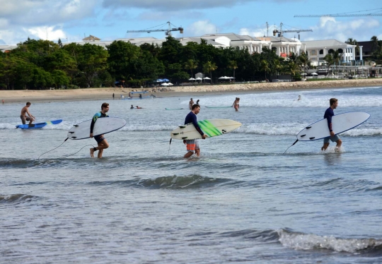 Potret turis asing asyik berjemur dan berselancar di Pantai Kuta