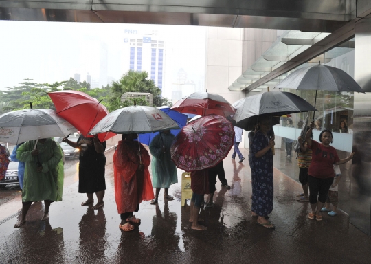 Potret pengojek payung mengais rezeki di tengah guyuran hujan