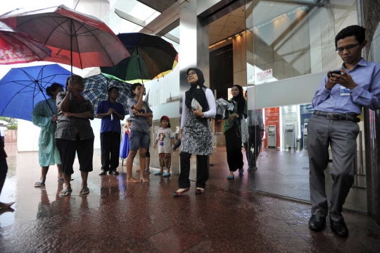 Potret pengojek payung mengais rezeki di tengah guyuran hujan