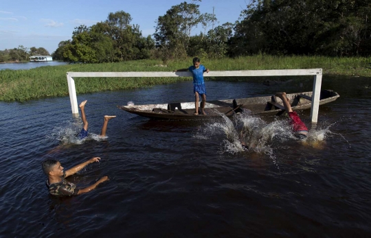 Keceriaan bocah Brasil main bola di atas Sungai Hitam Amazonas
