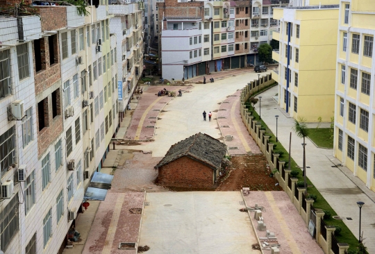 Menolak digusur, rumah ini berdiri di tengah jalan & gedung tinggi