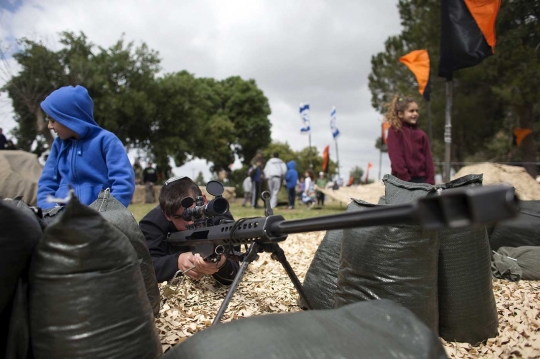 Aksi bocah Israel cicipi pegang senjata militer zionis