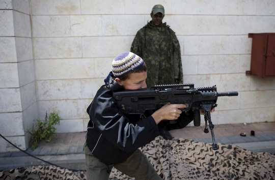 Aksi bocah Israel cicipi pegang senjata militer zionis