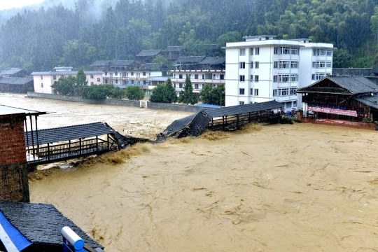 Dahsyatnya terjangan banjir di China rusak jembatan hingga rumah