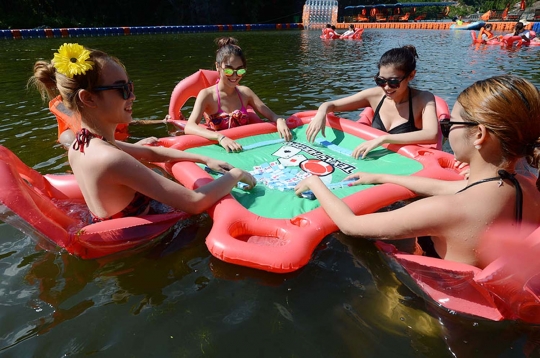 Hindari panas, warga China main mahjong di kolam renang