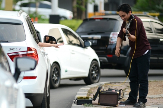 Kisah pengamen biola hibur pengendara di tengah kemacetan Ibu Kota