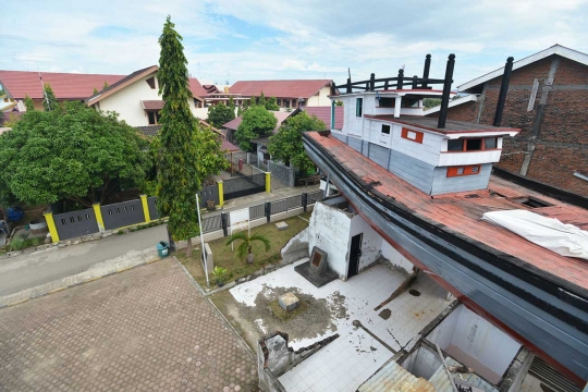 Mengunjungi situs tsunami, kapal tersangkut di atas rumah di Aceh