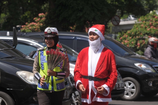 Aksi polisi berbaju Sinterklas bagikan bunga kepada pengguna jalan