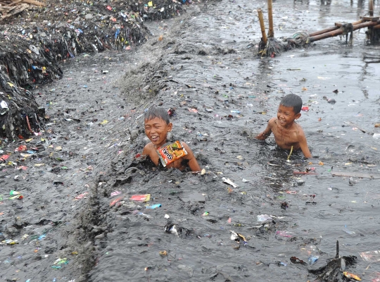 Keceriaan anak-anak Muara Angke berenang di pantai penuh sampah