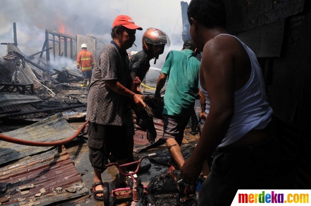 Warga sibuk mengevakuasi harta benda saat musibah kebakaran menimpa lingkungan tempat tinggal mereka di Kelurahan Bukit Duri.