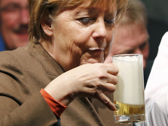 Ekspresi lucu Angela Merkel menyeruput bir