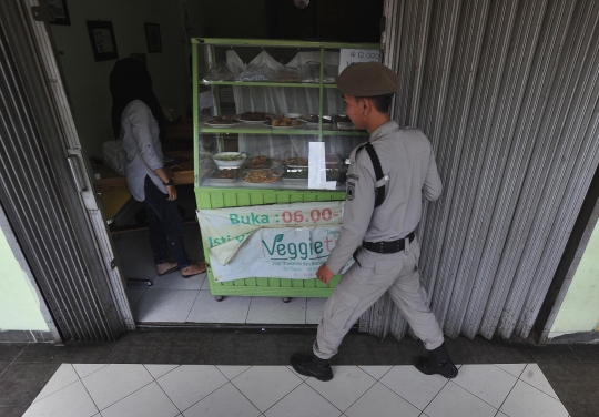 Kelakuan konyol warga asyik makan di tengah razia warung