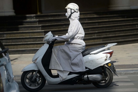 Cara unik warga Vietnam hindari panas saat naik motor