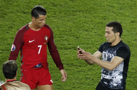 Wajah bete Cristiano Ronaldo diajak selfie fans di tengah lapangan