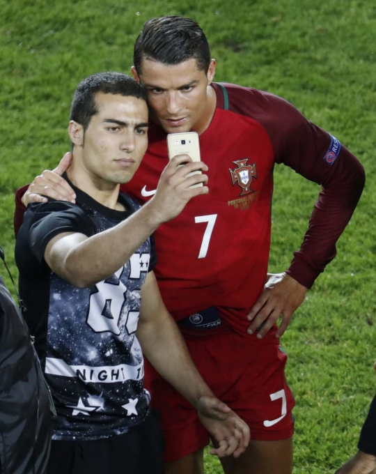 Wajah bete Cristiano Ronaldo diajak selfie fans di tengah lapangan