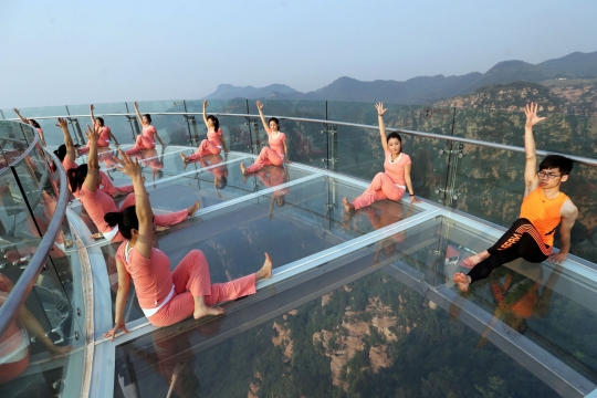 Aksi wanita-wanita seksi berlatih yoga di lantai kaca tepi jurang