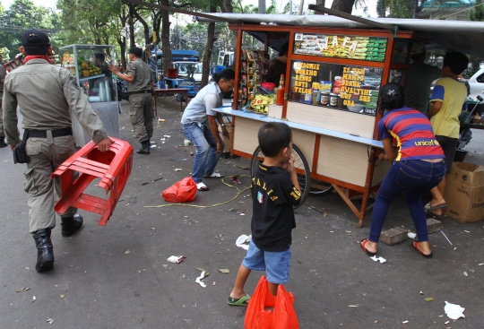 Aksi Satpol PP angkut gerobak PKL yang tempati pedestrian di Karet