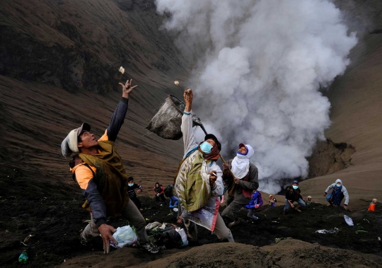 Nekatnya warga Tengger melempar sesaji di tengah erupsi Bromo
