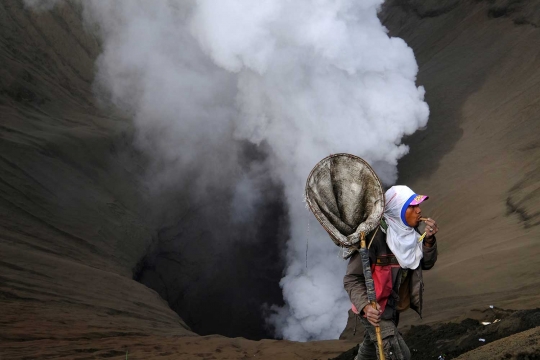 Nekatnya warga Tengger melempar sesaji di tengah erupsi Bromo