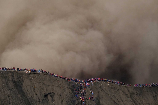 Nekatnya warga Tengger melempar sesaji di tengah erupsi Bromo