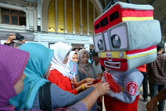 Aksi maskot KRL bagi-bagi bendera ke penumpang