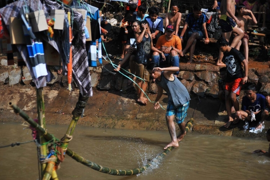 Keseruan lomba panjat pinang di atas aliran Kalimalang