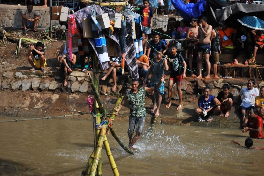 Keseruan lomba panjat pinang di atas aliran Kalimalang