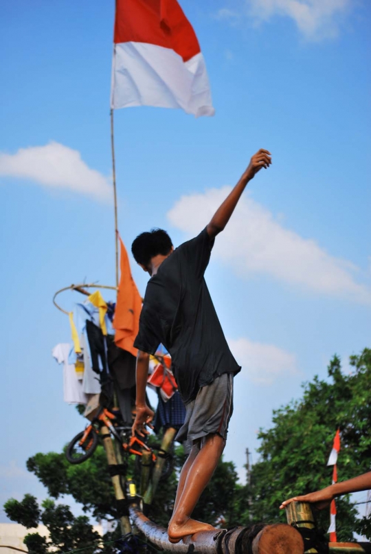 Keseruan lomba panjat pinang di atas aliran Kalimalang