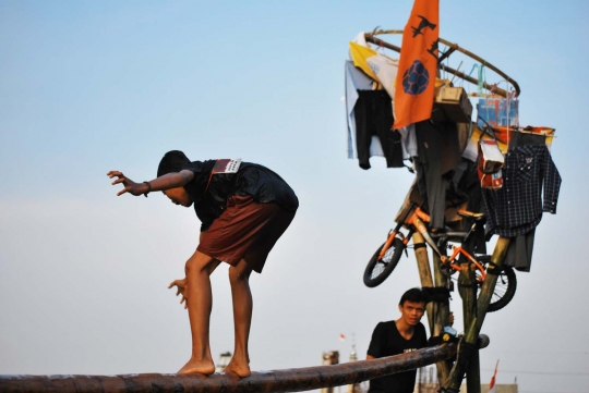 Keseruan lomba panjat pinang di atas aliran Kalimalang